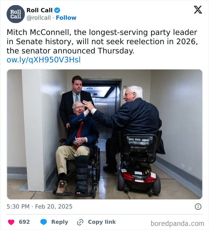 Two elderly men in wheelchairs exchanging a high-five in a plain hallway, reflecting modern life and boring dystopia.