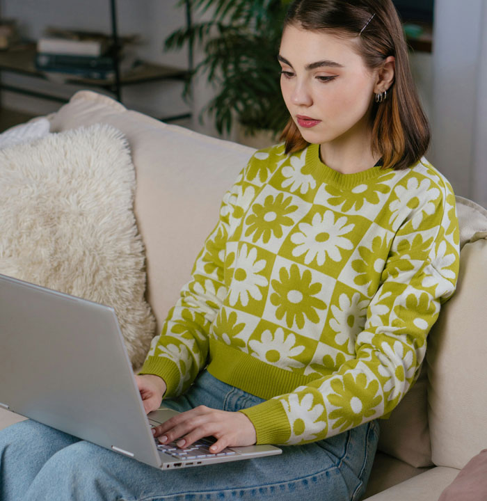 Young woman sitting on couch using laptop, researching dog attacks and dangerous dogs around kids. Young woman sitting on couch using laptop, researching dog attacks and dangerous dogs around kids.