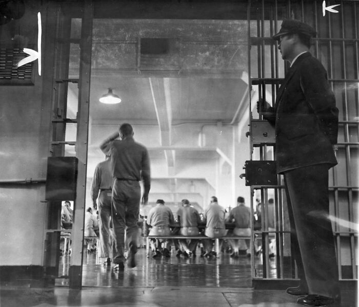 Prison guards overseeing inmates inside a cell block, showing a rare glimpse into life on Alcatraz prison.