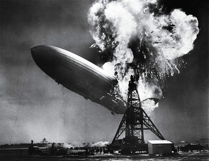 Historic photo of a burning airship disaster with dramatic smoke and flames captured in a rare historical moment.