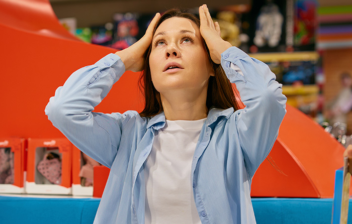 A stressed woman at work looks upward, reacting to a manager calling her useless in a challenging office moment.