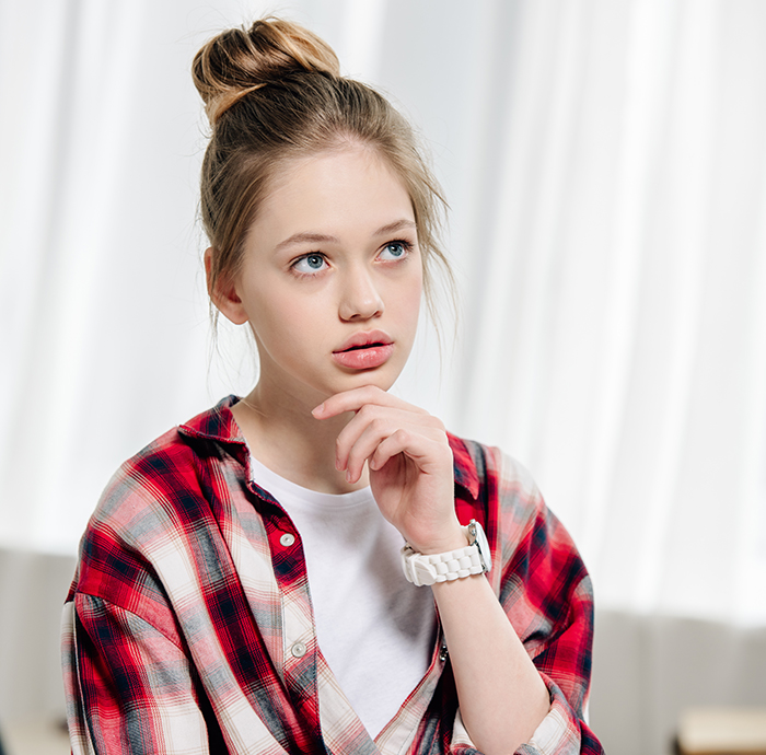 Thoughtful young woman in a red plaid shirt, reflecting on family issues involving man refusing stepdaughter with his kids.