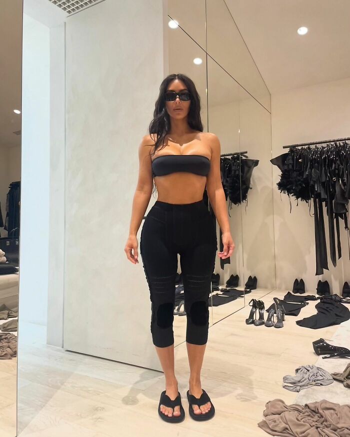 Kim Kardashian in a black outfit and sunglasses standing in a room, related to Anthony Hopkins Hannibal Lecter parody.