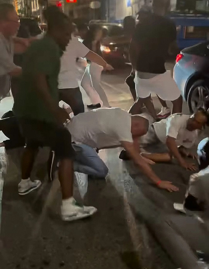 People involved in a violent Cincinnati brawl with a mom knocked out, shown on the ground during a chaotic street fight.