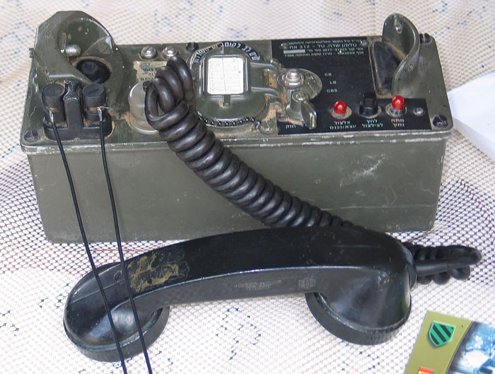 Vintage military communication device with handset and coiled cord, showcasing an unusual family flex tech gadget.
