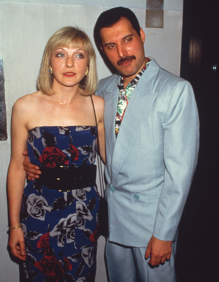 Freddie Mercury posing with a woman, both dressed in formal attire, amid love child controversy and backlash.