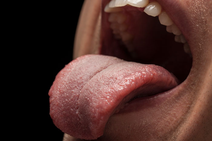 Close-up of a person sticking out their tongue, illustrating a wild scene involving licking a security camera.