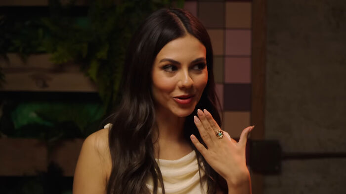 Young woman with long dark hair wearing a white top, discussing celebrities Hollywood tried to make leading A-listers