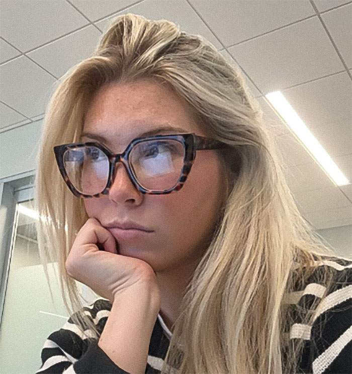 Young woman wearing glasses with a serious expression reflecting a heated debate about passenger slamming refusal to watch bag in airport. Young woman wearing glasses with a serious expression reflecting a heated debate about passenger slamming refusal to watch bag in airport.