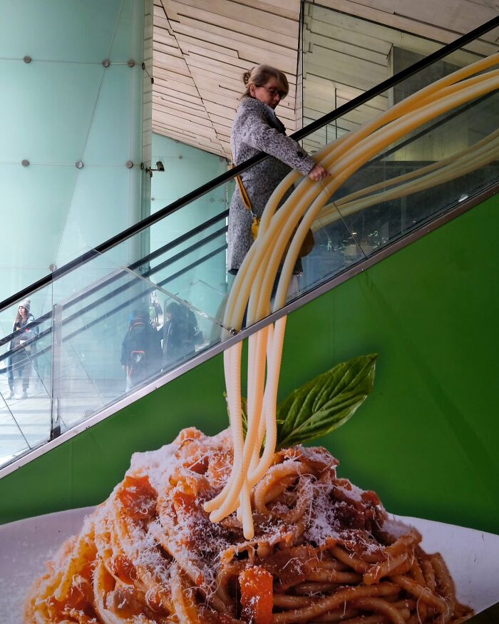 Woman on escalator appears to hold giant spaghetti, showcasing photographer captures unseen unposed moments on the streets.