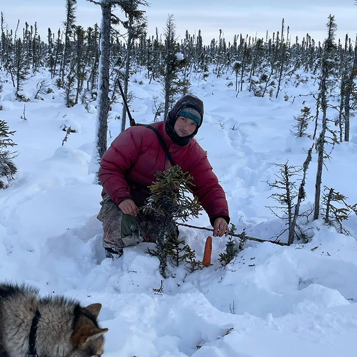 Man hiking alone in snowy wilderness with dog nearby, highlighting risks of lone hiking and search for missing hiker.