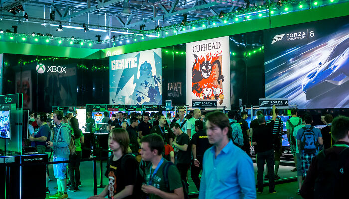 Crowded gaming event showcasing Xbox PR campaigns and decisions with multiple game displays and attendees walking around.