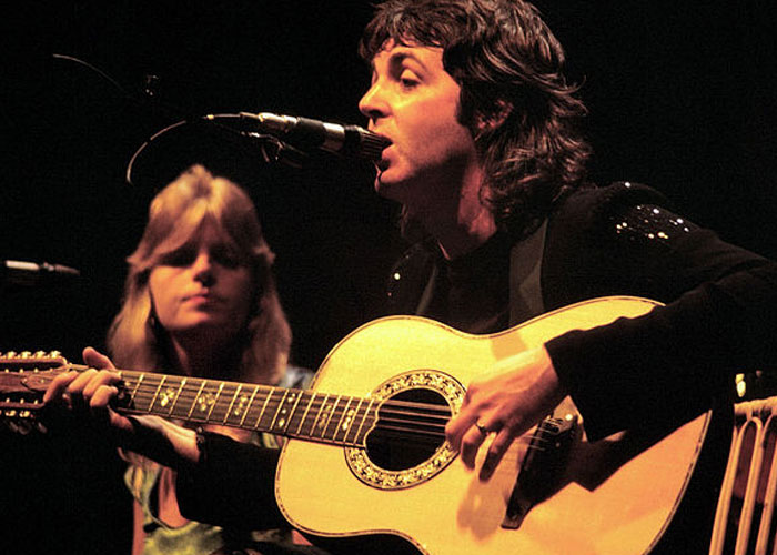 A musician playing guitar and singing on stage, capturing a moment from celebrity encounters and wild experiences.