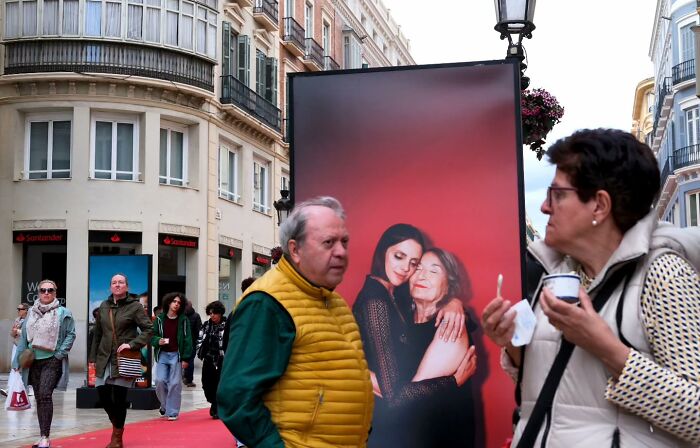 Street moments captured candidly showing people walking and interacting near urban art in a lively city scene.