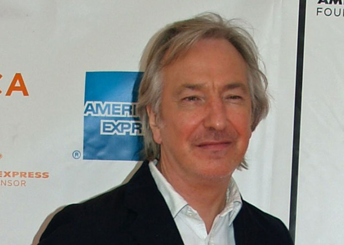 Actor Alan Rickman attending a red carpet event, showcasing a total gentleman vibe in a black blazer and white shirt.