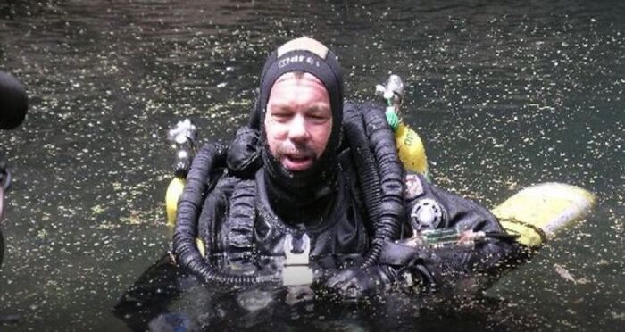 A diver in full scuba gear emerging from dark water, part of unsettling images from Morbid Knowledge group.