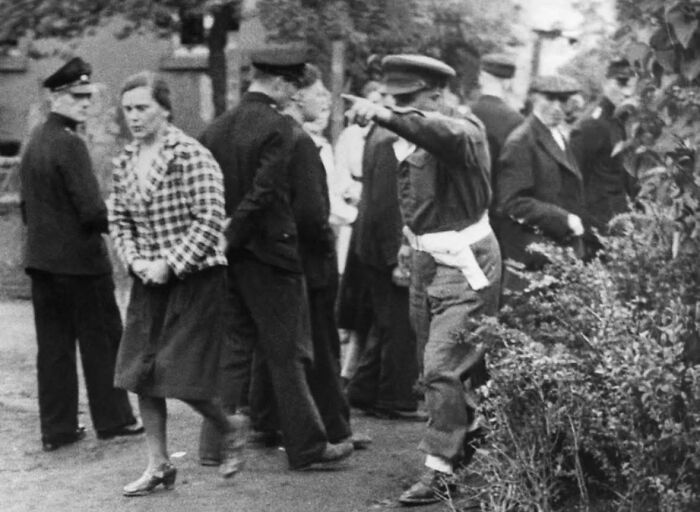 Black and white historical photo showing police interacting with civilians, capturing an interesting and heartbreaking moment.