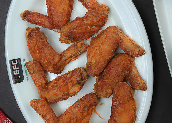 Plate of crispy fried chicken wings served as a popular snack during wild and embarrassing drinking stories gatherings.