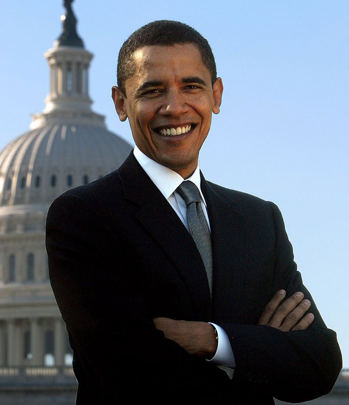 Man in a suit standing with arms crossed in front of a government building, showcasing an insane family flex.