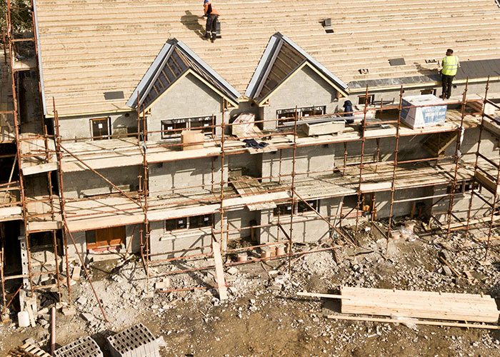 Construction workers on scaffolding building a house, illustrating jobs associated with person without a soul.