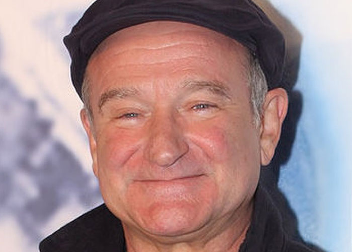 Smiling celebrity wearing a dark cap and jacket, a total gentleman captured during a casual public event.