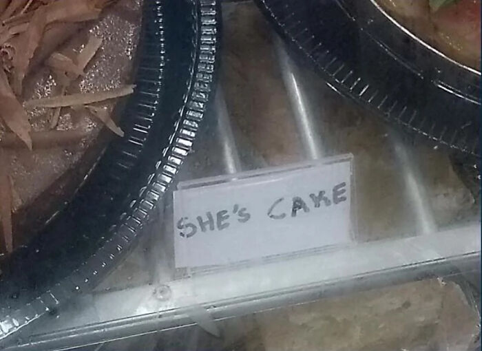 Handwritten display sign with typo saying "SHE'S CAKE" on a bakery shelf, illustrating common typos.