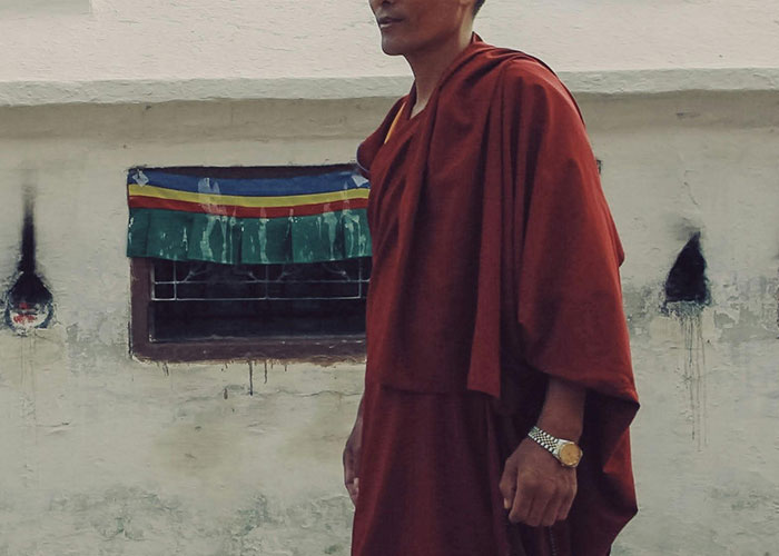 Man wearing a red robe standing outdoors near a weathered wall, illustrating wild and embarrassing drinking stories.