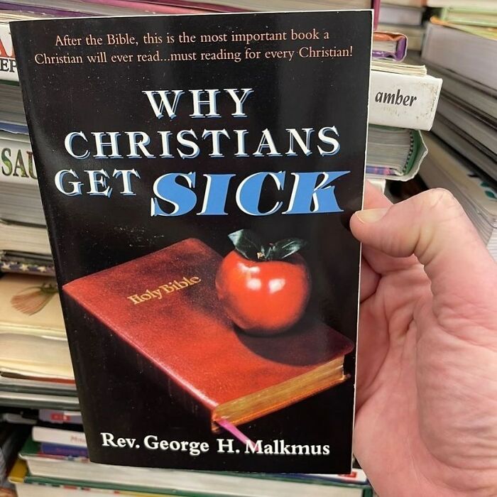 Book titled Why Christians Get Sick held at thrift store with Holy Bible and apple on cover, unusual thrift store find.