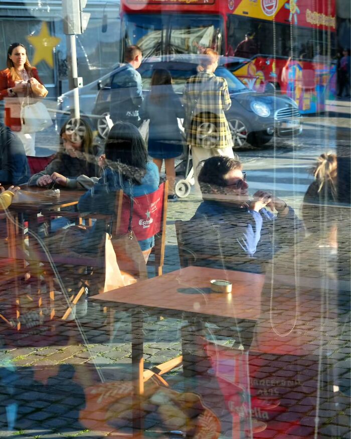 Street scene with people unposed and captured through reflective window showing life’s unseen moments.