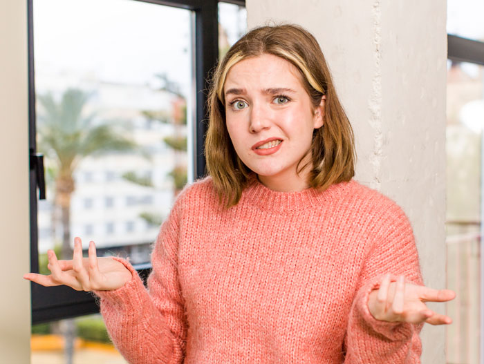 Woman in a pink sweater wondering if she should explain that separation and divorce are not the same to her husband