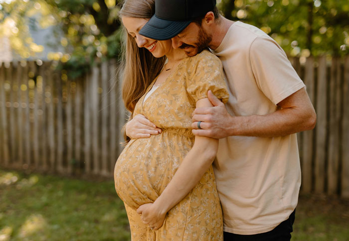 Pregnant woman in a yellow dress embraced by man outdoors, highlighting insecurities and relationship ultimatum.