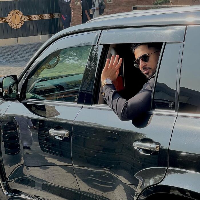 Man in sunglasses inside black car, raising hand, related to intoxicated man's horrifying threat and supermodel wife defends pain. Man in sunglasses inside black car, raising hand, related to intoxicated man's horrifying threat and supermodel wife defends pain.