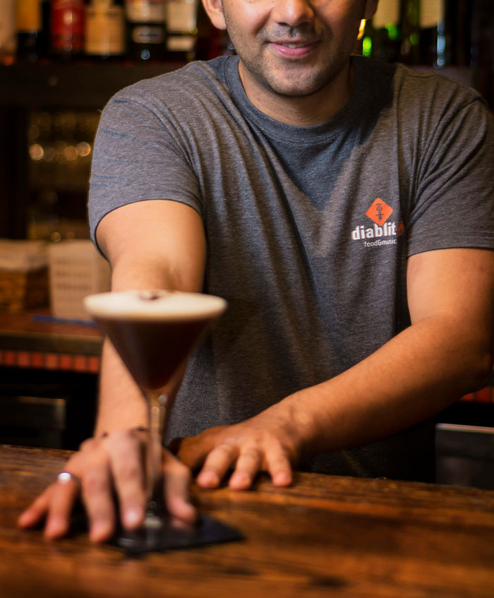 Bar staff serving a cocktail, exemplifying stories of bar staff and customers protecting women from unwanted attention.
