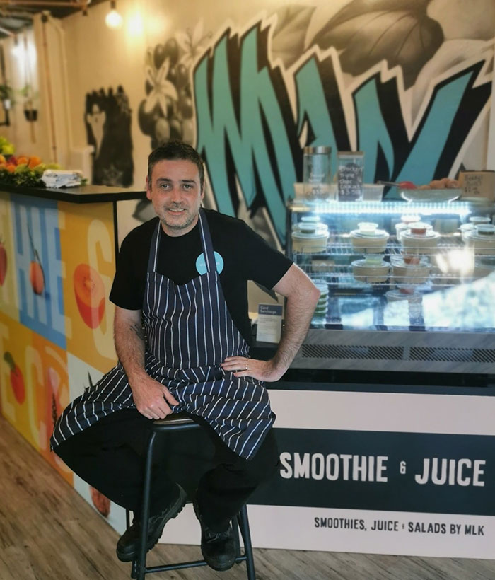 Caf&eacute; owner in apron addressing entitled customers after teen worker was left in tears at smoothie and juice shop.