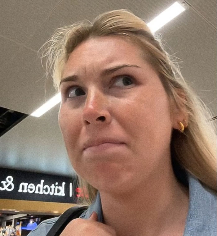 Young woman at airport with concerned expression during heated debate about refusing to watch her bag closely Young woman at airport with concerned expression during heated debate about refusing to watch her bag closely