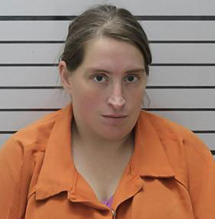 Woman in an orange jumpsuit in a mugshot, related to stepdad and mom facing felony charges after home birth without medical help.