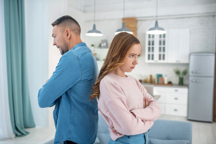 Man and wife standing back to back in kitchen, looking upset during a disagreement about wife getting a job. Man and wife standing back to back in kitchen, looking upset during a disagreement about wife getting a job.