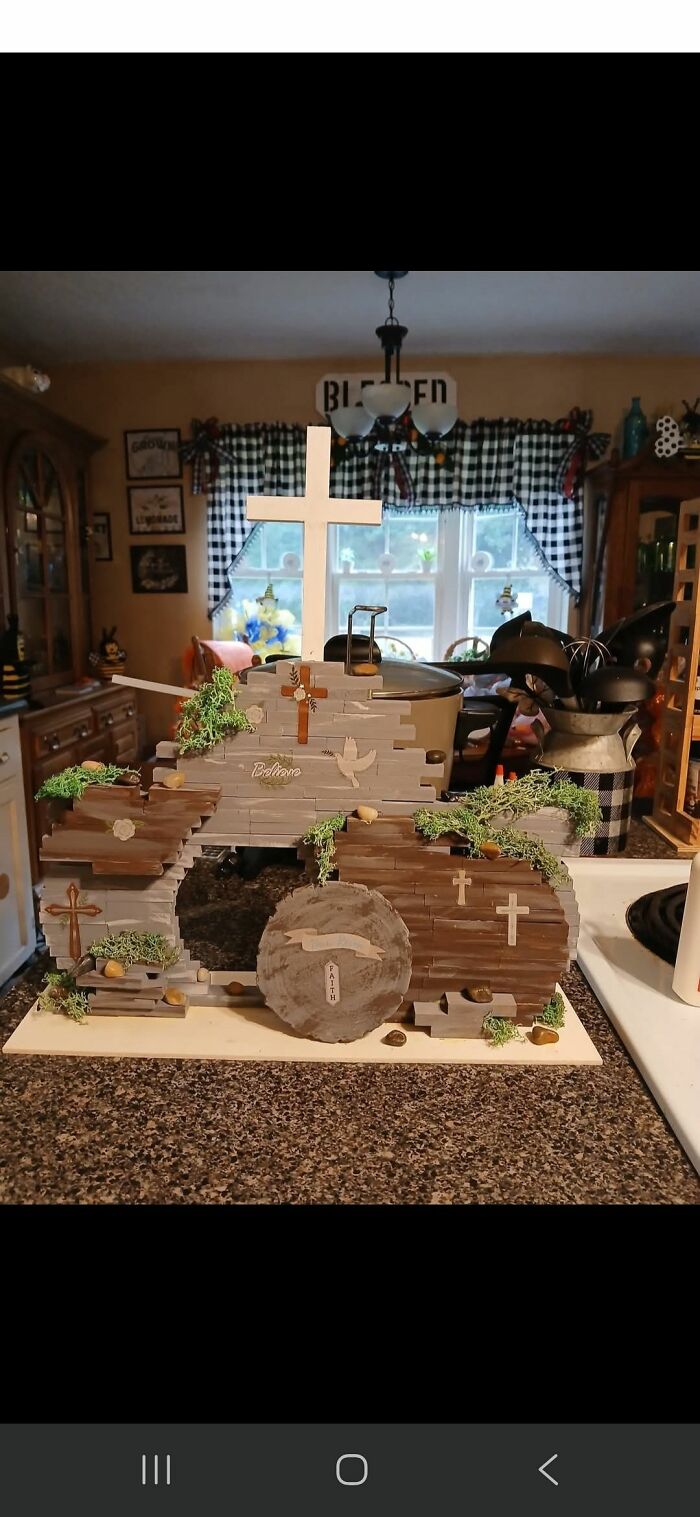 DIY craft project with wooden crosses and greenery on a kitchen counter, showcasing handmade religious-themed decor.