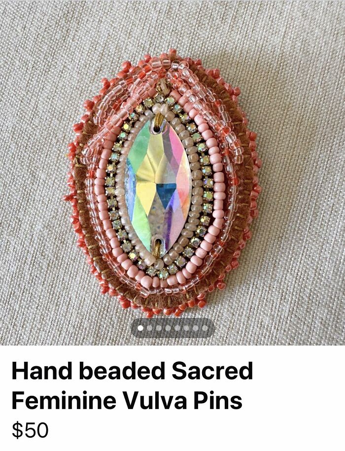 Beaded handmade vulva pin with pink and clear beads surrounding a reflective crystal, representing craft shaming DIY project.