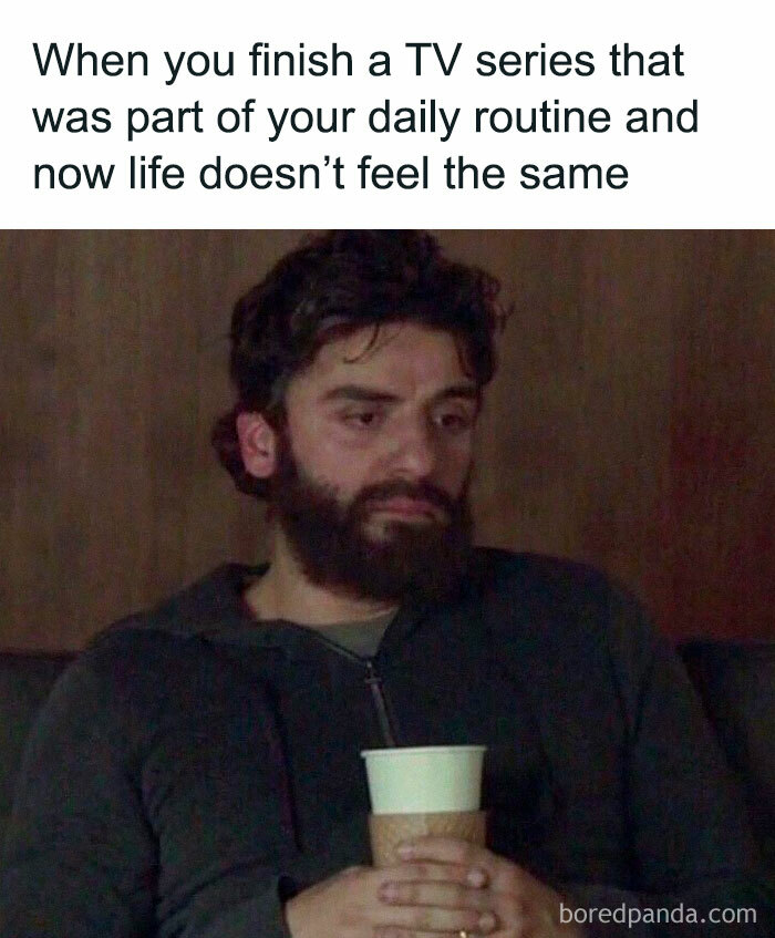 Bearded man with a somber expression holding a cup, illustrating introvert-worthy memes about daily routine changes.