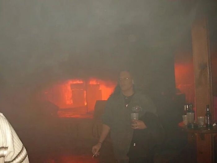 Person standing in a smoky room with a glowing red background, creating an unsettling atmosphere from morbid knowledge images.