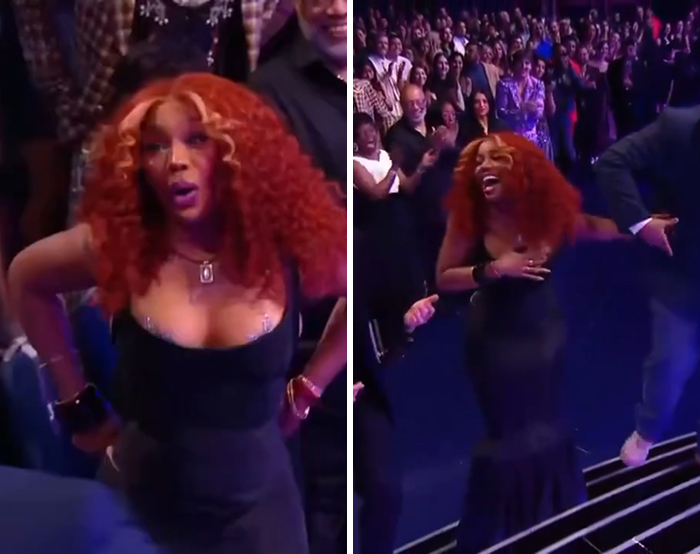 Celebrity experiencing a wardrobe malfunction moment in a black dress with red curly hair at a crowded event fans can't unsee.