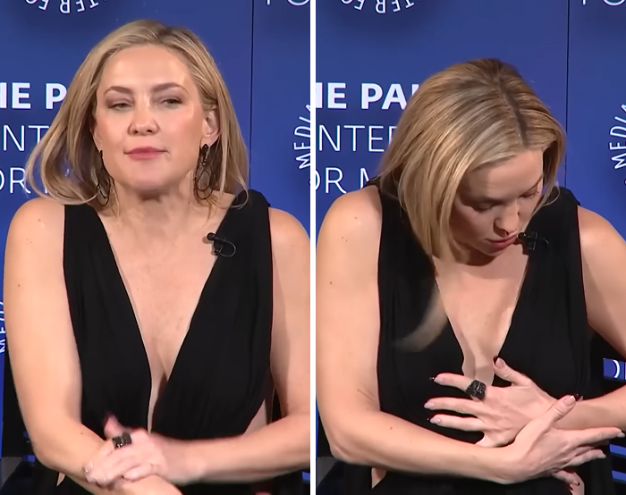 Actress wearing a black dress experiencing a celebrity wardrobe malfunction moment during a media event interview.