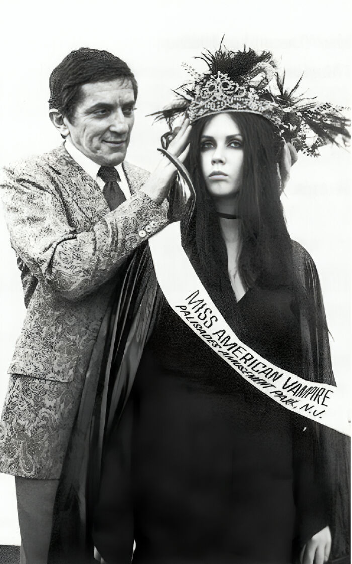 Black and white historical photo of a man crowning a woman wearing a Miss American Vampire sash and crown.