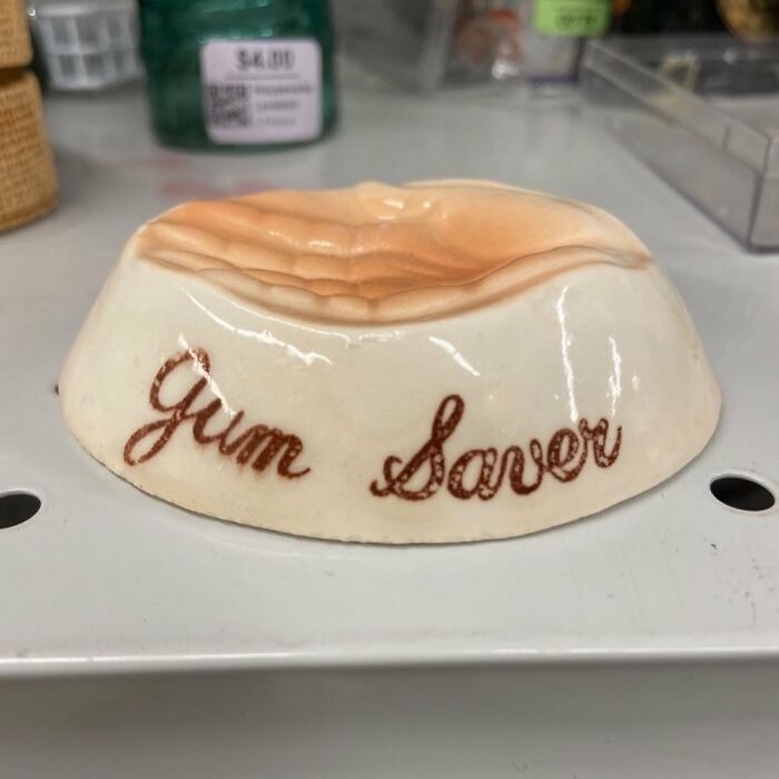 Ceramic vintage gum saver shaped like gums, found among bizarre thrift store items on a store shelf.