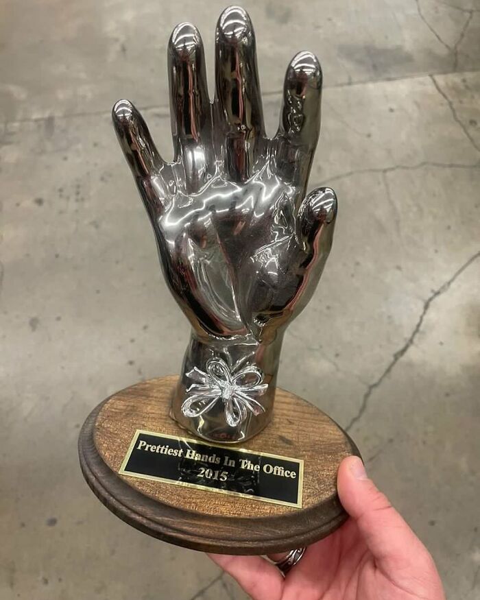 Shiny metallic hand trophy labeled prettiest hands found among bizarre thrift store discoveries.