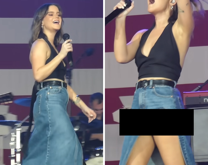 Female singer wearing a black top and denim skirt experiencing a celebrity wardrobe malfunction moment on stage.