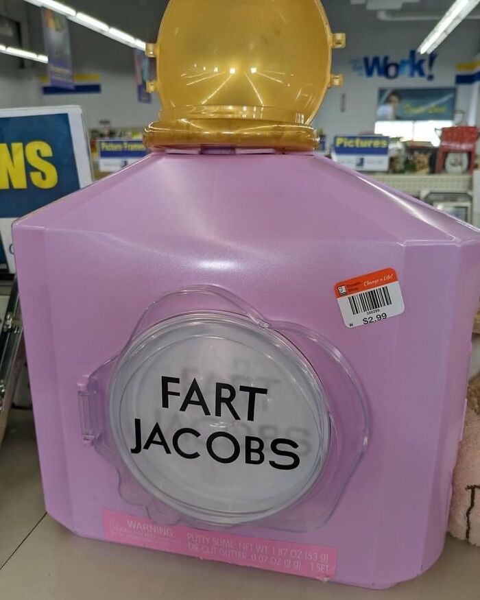 Large purple container with a yellow lid and a label reading Fart Jacobs found in a thrift store aisle.