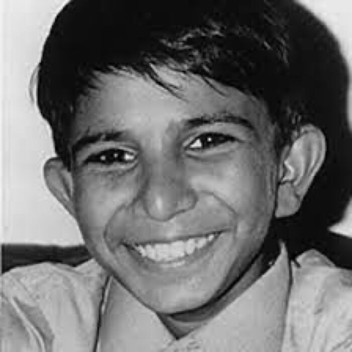 Black and white portrait of a smiling young boy, featuring unsettling images from Morbid Knowledge online group collection.