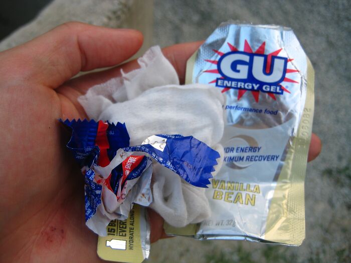 Hand holding crumpled snack wrappers and tissues, illustrating snooping parents accidentally uncovering kids’ secrets.